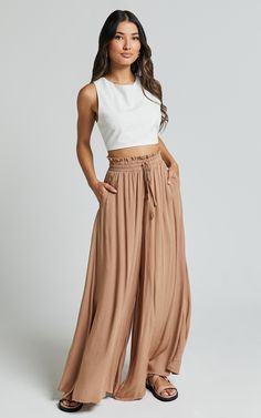 Get ready to elevate your casual pants game with our Hany Pants in Latte! These high waist drawstring wide leg pants are the epitome of relaxed chic. Made from soft and breathable rayon fabric, they offer ultimate comfort without compromising on style. The latte brown hue adds a touch of sophistication to any outfit, making these pants perfect for both everyday wear and special occasions. With their full length design, the Hany Pants effortlessly elongate your legs while providing a flattering f Loose Flowy Pants, Flowy Boho Pants, Flowy Pants Outfit Dressy, Brown Trousers Outfit Women, Hippie Pants Outfit, Pants Outfit Dressy, Boho Chic Pants, Flowy Pants Outfit, Loose Pants Outfit