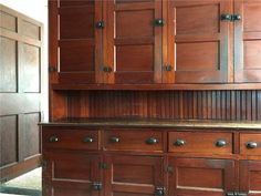 an old wooden cabinet with metal handles and knobs on the doors is shown in this photo