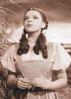 an old black and white photo of a woman with two baby birds in her hands