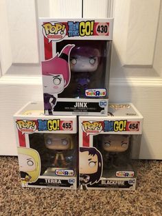 three funky pop vinyls are sitting on the floor in front of a white door