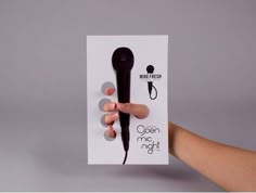 a hand holding up a black hair dryer on top of a white card that says ocean night club