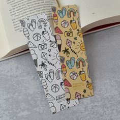 two bookmarks are sitting next to an open book