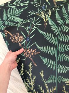 a person holding onto a black and green wallpaper