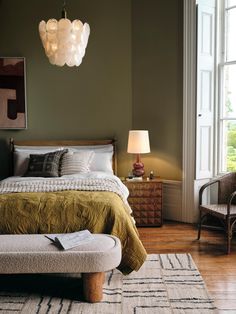 a bedroom with a large bed and two lamps hanging from the ceiling over it's headboard