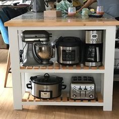 a kitchen island with pots, pans and mixers sitting on top of it