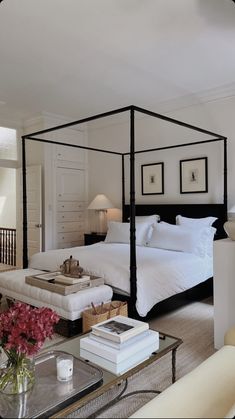 a bedroom with a four poster bed and white walls