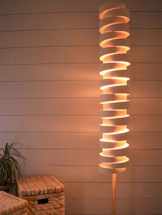 a lamp that is sitting on top of a wooden table next to a basket and plant