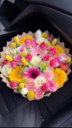 a bouquet of flowers sitting on the dashboard of a car