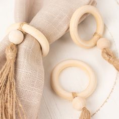 two wooden rings with tassels are sitting next to a burlap bag