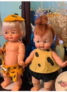 two dolls are standing next to each other