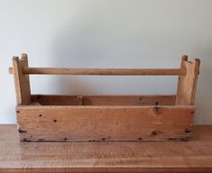 a wooden box sitting on top of a table next to a white wall and floor