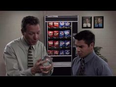 two men looking at something in front of a vending machine