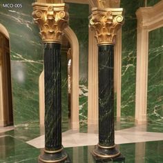 two black and gold marble pillars in a room with green marble flooring on the walls