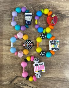 several different colored candies on a wooden table with name tags and magnets attached to them