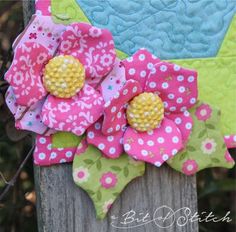 a close up of a flower on top of a wooden fence post with flowers in the center