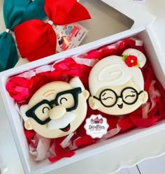 two decorated cookies in a box on a table