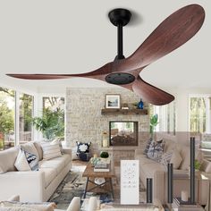 a living room filled with furniture and a ceiling fan in front of a fire place