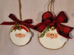 two christmas ornaments hanging from twine with bows