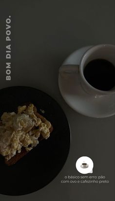 a black plate topped with food next to a cup of coffee