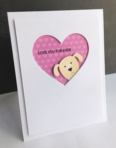 a white card with a pink heart and a brown dog on it's side