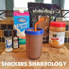 there are some peanut butter and other foods on the table with words that read, snickkers shakeology