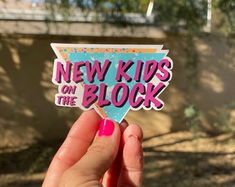 someone holding up a sticker that says new kids on the block