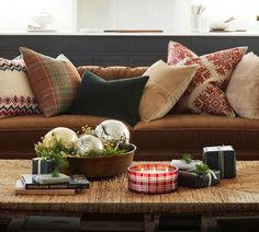 a living room filled with lots of furniture and pillows on top of a wooden table