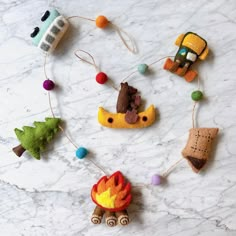 various felt toys are arranged on a marble counter top, including an ornament