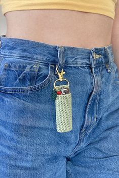 a cell phone in the back pocket of someone's jeans with a keychain attached to it