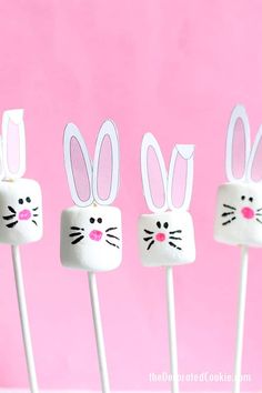 four marshmallows with bunny ears on them in front of a pink background