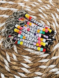 several key chains with words written on them sitting in a woven basket next to each other