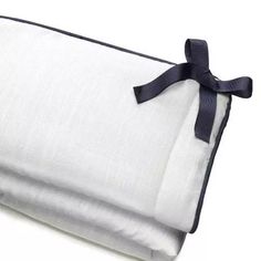 a white and blue blanket folded up on top of each other with a black ribbon