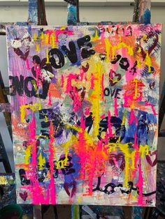 an easel with some paint on it and the words love is written in different colors