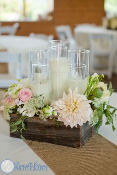 a wooden box with candles and flowers on it