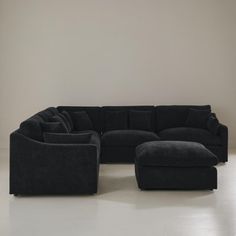 a large black couch sitting on top of a white floor