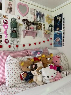 there are many stuffed animals sitting on the bed in this room with pink and white decor