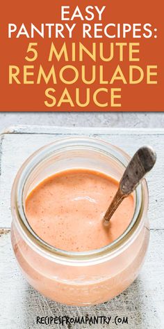 a jar filled with sauce sitting on top of a table next to a wooden spoon