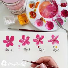 someone is painting flowers with watercolors on the paper and then using it to paint them