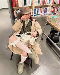 a person sitting in a chair with a handbag on their lap and holding a phone to her ear