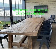 a large wooden table sitting inside of a room next to a glass wall covered in windows