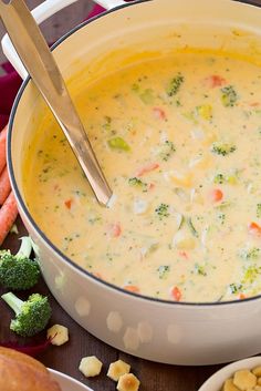 a bowl filled with broccoli, carrots and other food on a table