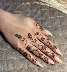 a woman's hand with henna tattoos on it