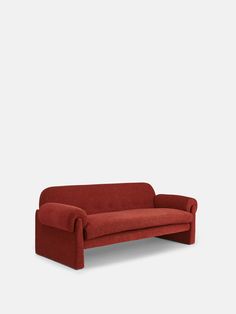 a red couch sitting on top of a white floor