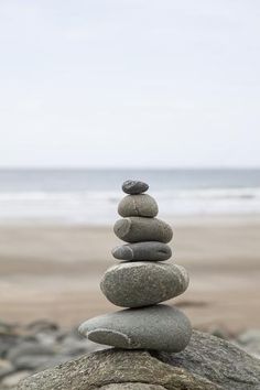 rocks stacked on top of each other in front of the ocean