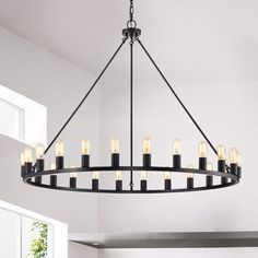 a large chandelier with candles hanging from it's centerpiece in a kitchen