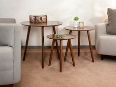 two small tables sitting next to each other on top of a carpeted room floor