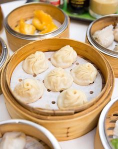 dim sumi dumplings in bamboo steamers on a table with other food items