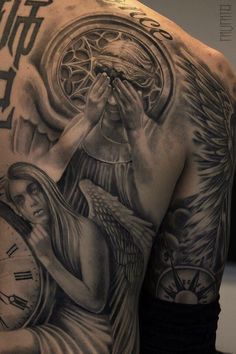 a man's back with an angel and clock tattoo on it