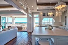 a large open concept kitchen and living room with an ocean view from the dining area