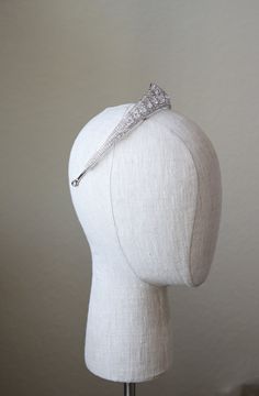 a white mannequin head with a diamond hair clip on it's head